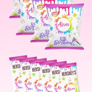 May include: A set of 10 personalized chip bags with a paint splatter design. The bags are white with pink and blue paint splatters and say "Alexa's 8th Birthday" on them. The bags are perfect for a birthday party.