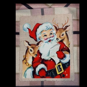 May include: A vintage-style illustration of Santa Claus in a red suit and hat, reading a paper, flanked by two reindeer. The image has a classic, nostalgic feel, perfect for holiday decor.