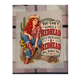 May include: A fabric panel featuring a red-haired cowgirl in a plaid shirt, blue jeans, and cowboy boots, sitting on a wooden fence with a cactus and sunflowers. The text reads: YOU CAN'T HANDLE A REDHEAD BUT IF YOU'RE LUCKY A REDHEAD WILL HANDLE YOU.