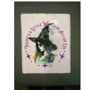 May include: Watercolor illustration of a witch with a black hat and the text "There's a little witch in all of us" in a purple circular design. The witch has a pale complexion and is surrounded by green and purple accents.