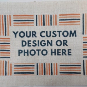 May include: A white canvas banner with a border of orange and blue stripes. The banner has the text "YOUR CUSTOM DESIGN OR PHOTO HERE" in dark blue letters.