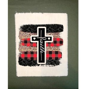 May include: A white canvas with a black cross and the word "faith" written vertically on it. The cross is surrounded by red and black buffalo plaid, leopard print, and black brushstrokes.