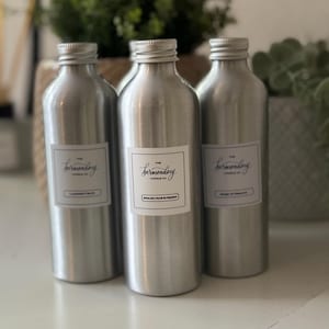 Puede incluir: Tres tarros de velas de metal plateado con etiquetas que dicen "The Bermondsey Candle Co." y los aromas "Lavanda & Cedro", "Pera Inglesa & Fresia" y "Mango & Tabaco".