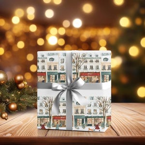 a present wrapped in white paper with a silver bow