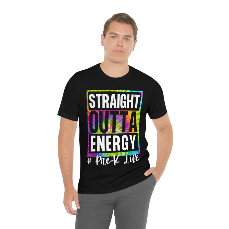 Pode incluir: Camiseta preta com um design tie-dye e o texto "Straight outta energy #Pre-K Life" em branco.