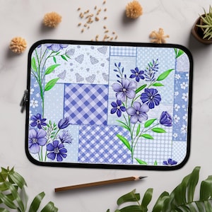 May include: A blue and white laptop sleeve with a patchwork design featuring purple flowers and gingham patterns.