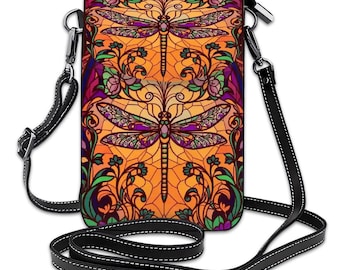 May include: A crossbody bag with a stained-glass design featuring two dragonflies. The bag has a black strap and a zipper closure. The dragonfly design includes purple, green, and orange colors.