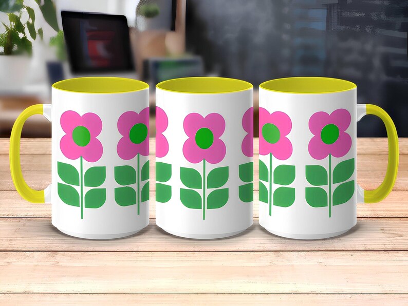 Three white mugs with green and pink flower designs on a wooden surface.