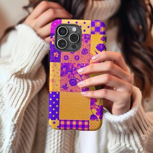 Può includere: Una custodia per telefono di colore viola e giallo con un design a patchwork che presenta fiori e motivi geometrici.