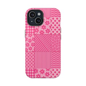 Può includere: Una custodia per telefono rosa con un design patchwork. La custodia presenta vari motivi, tra cui pois, strisce, fiori e quadretti, tutti in tonalità di rosa. Le lenti della fotocamera del telefono sono visibili nella parte superiore.
