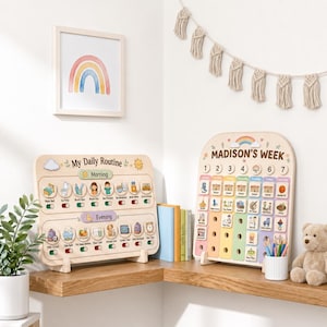 May include: Two wooden activity boards for children. The left board is labeled My Daily Routine with morning and evening tasks featuring sliding toggles. The right board is labeled Madison's Week with numbered columns and colorful task icons.