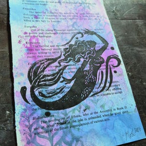 Może przedstawiać: Czarna ilustracja syreny na stronie książki z widocznym tekstem. Tło ma efekt akwareli w odcieniach niebieskiego, fioletowego i różowego. Grafika jest podpisana "Mos 2005".