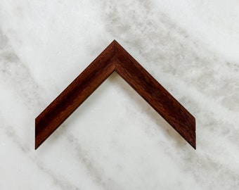 May include: A dark brown wooden picture frame with a beveled edge.