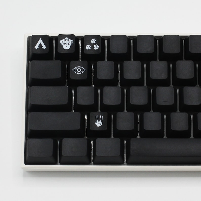 Peut inclure: Un clavier m&eacute;canique noir avec des touches personnalis&eacute;es repr&eacute;sentant des symboles du jeu vid&eacute;o Apex Legends. Les touches comprennent un symbole pour le personnage Bloodhound, un symbole pour le personnage Pathfinder, un symbole pour le personnage Octane et un symbole pour le personnage Wraith.