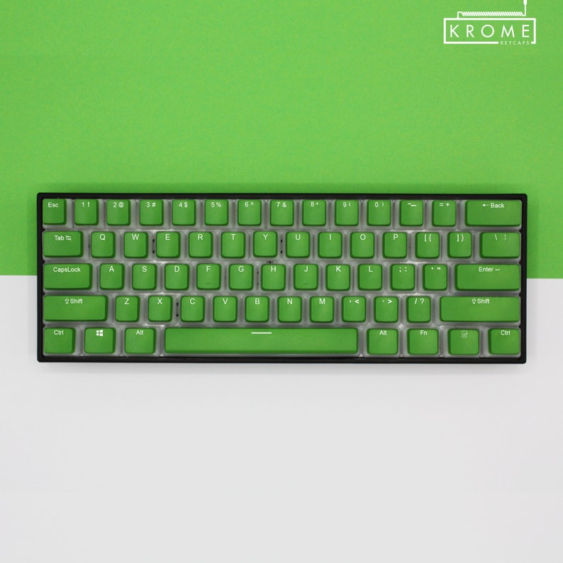 May include: A compact, black mechanical keyboard with bright green keycaps. The keyboard features a standard QWERTY layout with alphanumeric keys, function keys, and a space bar. The brand name "KROME KEYCAPS" is visible in the top right corner.