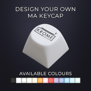 May include: A white MA keycap with the text "DESIGN YOUR OWN MA KEYCAP" and "KROME KEYCAPS" printed on it. The image shows a variety of available colours for the keycap, including black, white, and various pastel shades.