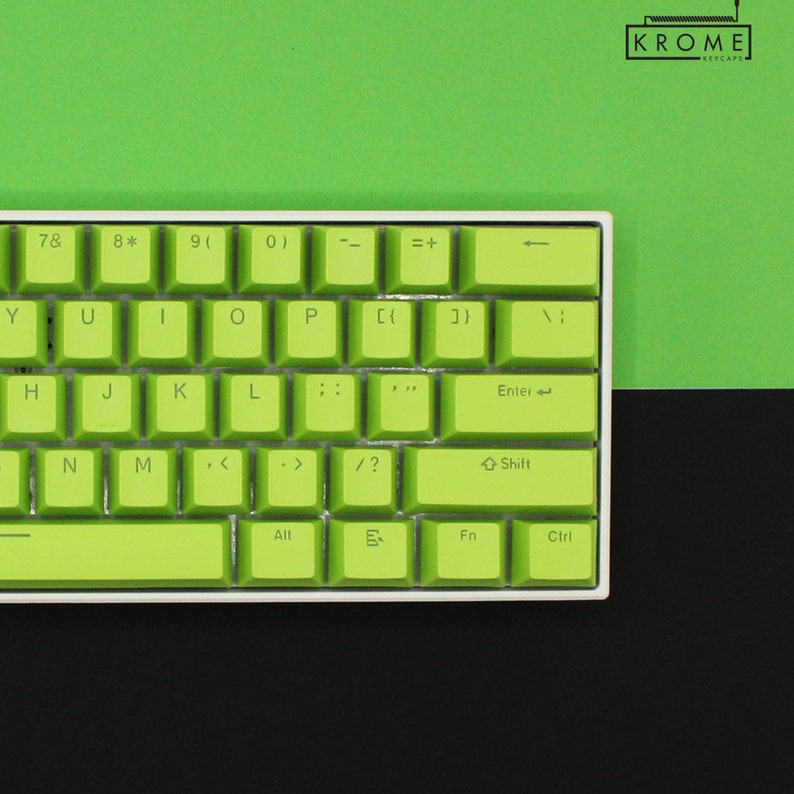May include: A green and white keyboard with the letters 7, 8, 9, 0, Y, U, I, O, P, H, J, K, L, ;, ' , N, M, <, >, /, ?, Enter, Shift, Alt, Fn, and Ctrl. The keyboard has a white frame and green keys. The keyboard is on a green and black surface.