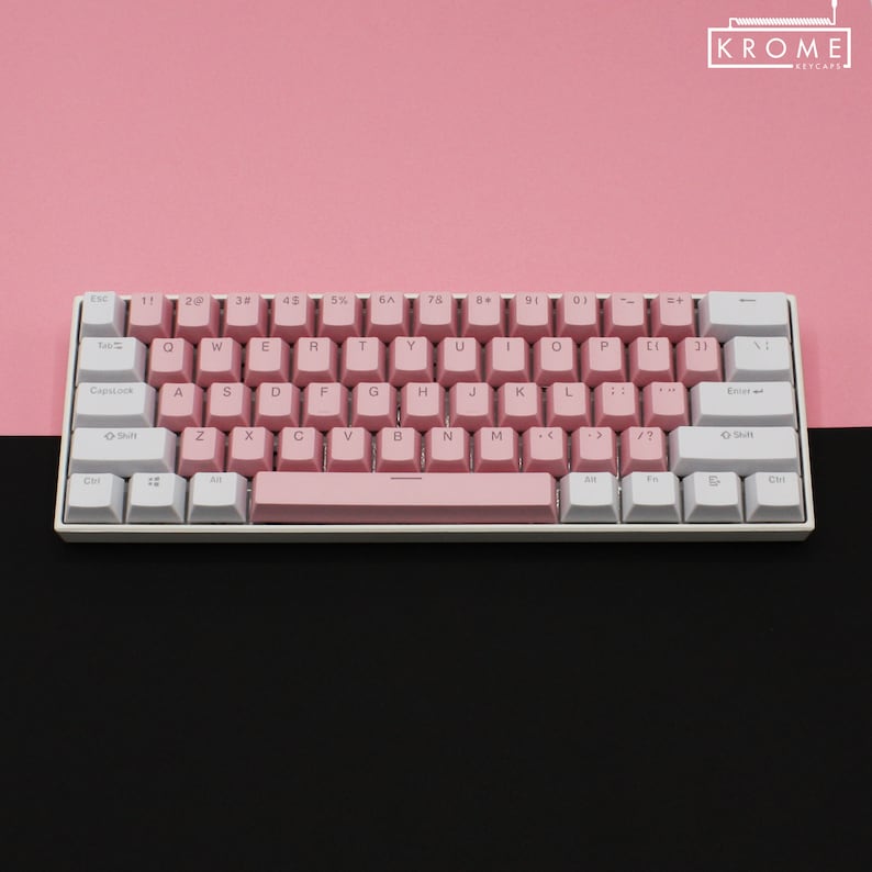 May include: A white and pink mechanical keyboard with a pink space bar and white keycaps. The keyboard has a pink and white color scheme and features the text "KROME KEYCAPS" in the top right corner.