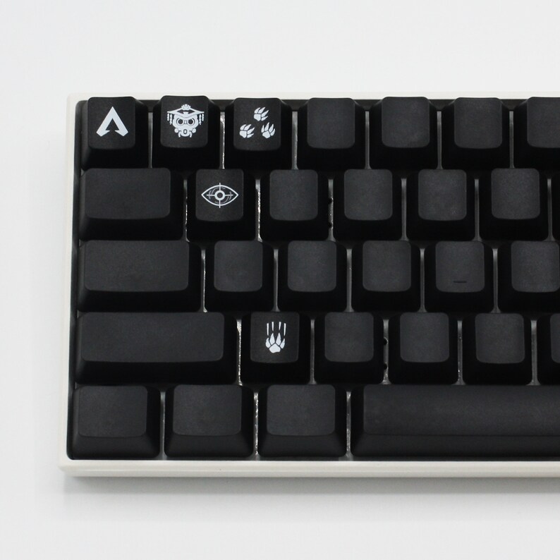 Pode incluir: Um teclado mec&acirc;nico preto com teclas personalizadas que apresentam s&iacute;mbolos do videogame Apex Legends. As teclas incluem um s&iacute;mbolo para o personagem Bloodhound, um s&iacute;mbolo para o personagem Pathfinder, um s&iacute;mbolo para o personagem Octane e um s&iacute;mbolo para o personagem Wraith.