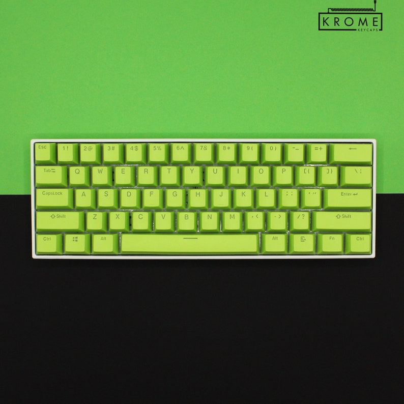 May include: A white mechanical keyboard with green keycaps. The keys are labeled with the standard QWERTY layout. The keyboard has a white frame and a black bottom row.
