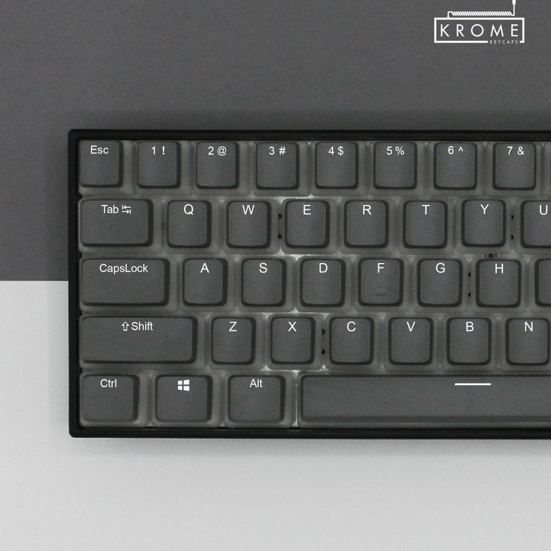 May include: A black keyboard with clear keycaps and white lettering. The keyboard has a standard layout with function keys, number keys, and letter keys. The keyboard also has a Caps Lock key, a Shift key, a Ctrl key, and an Alt key.