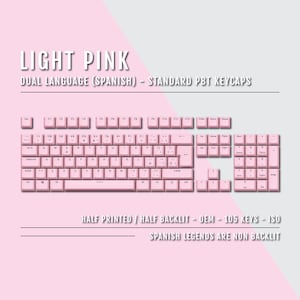 Könnte beinhalten: Eine hellrosa Tastatur mit Standardlayout und spanischen Sprachtasten. Die Tastatur ist halb bedruckt und halb beleuchtet. Die Tastenkappen sind aus PBT-Kunststoff. Die Tastatur hat 105 Tasten und entspricht dem ISO-Standard. Die spanischen Legenden sind nicht beleuchtet.