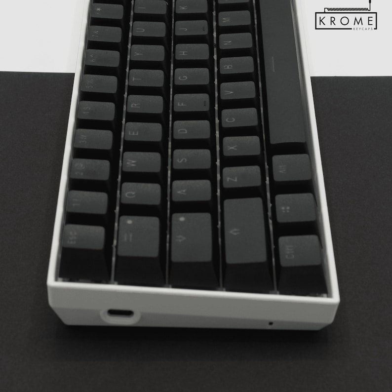 May include: A white mechanical keyboard with black keycaps. The keyboard has a minimalist design and features a USB-C port on the side.