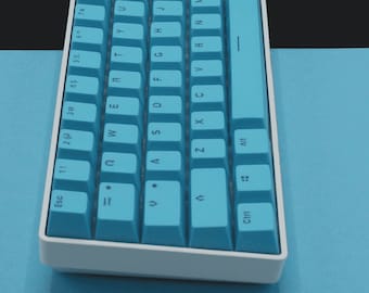 Könnte beinhalten: Eine weiße und blaue mechanische Tastatur mit einem blauen Tastenset. Die Tastatur hat einen weißen Rahmen und eine blaue Leertaste. Die Tasten sind mit dem Standard-QWERTY-Layout beschriftet.