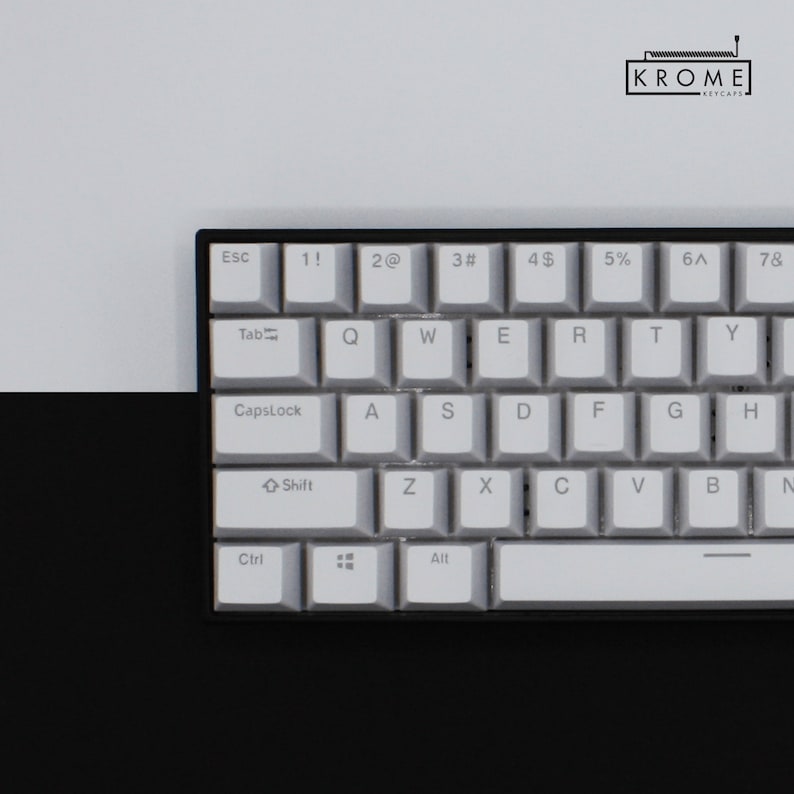May include: A white mechanical keyboard with black keycaps and a black frame. The keys have white lettering and symbols. The keyboard has a row of function keys at the top, a row of number keys, a row of letter keys, and a row of modifier keys. The keyboard also has a space bar, a backspace key, and an enter key.
