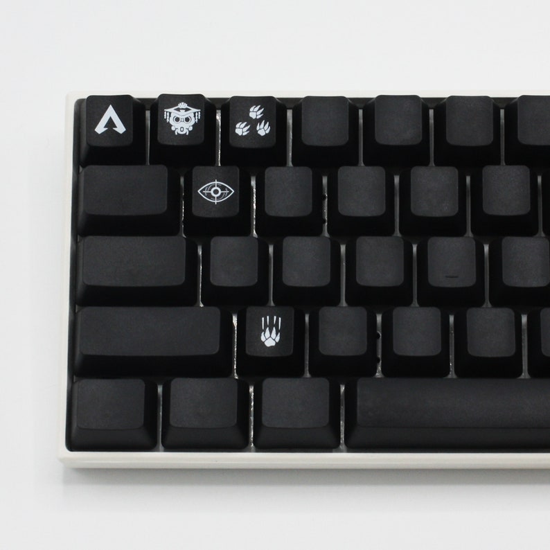 May include: A black mechanical keyboard with custom keycaps featuring symbols from the video game Apex Legends. The keycaps include a symbol for the character Bloodhound, a symbol for the character Pathfinder, a symbol for the character Octane, and a symbol for the character Wraith.