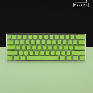 May include: A compact, white mechanical keyboard with bright green keycaps. The keyboard features a standard QWERTY layout with a variety of function keys. The brand name "KROME KEYCAPS" is displayed in the upper right corner.
