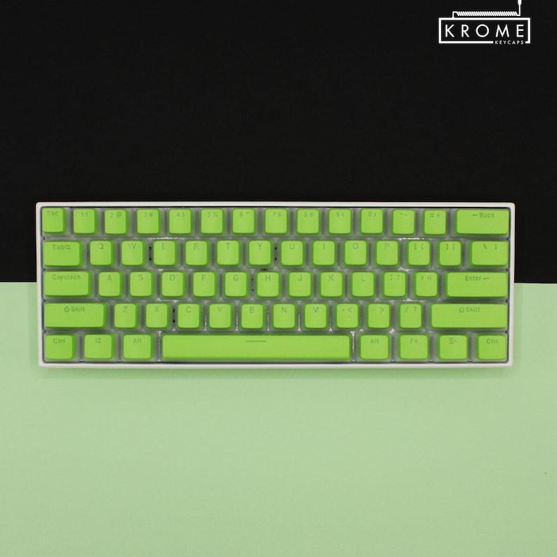 May include: A compact, white mechanical keyboard with bright green keycaps. The keyboard features a standard QWERTY layout with a variety of function keys. The brand name "KROME KEYCAPS" is displayed in the upper right corner.