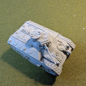 May include: A gray plastic model of a tank with a turret and a cannon. The tank has a detailed design with tracks and wheels.