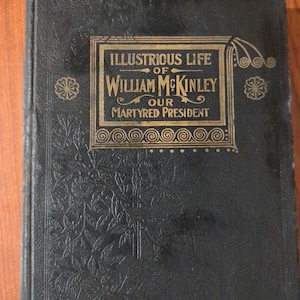 May include: Black book with gold lettering on the cover. The title is "Illustrious Life of William McKinley Our Martyred President".