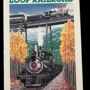May include: A vintage print of the Georgetown Loop Railroad. The image features a black steam train on a track, with the text "Georgetown Loop Railroad" at the top. The background includes trees and a bridge.