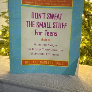 May include: A book titled "Don't Sweat the Small Stuff For Teens" by Richard Carlson, Ph.D. The cover is light blue with a yellow border and polka dots. The title is in large purple letters.
