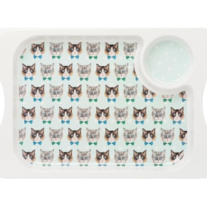May include: White serving tray with a light blue background and a pattern of cats wearing bow ties. The tray has two handles and a small, round, white bowl with a light blue background and white polka dots.