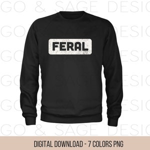 以下が含まれることがあります： 前面に「FERAL」という文字がくたびれたフォントで書かれた白い長方形が付いた黒いスウェットシャツです。