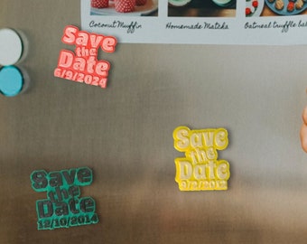 May include: Three refrigerator magnets with the text "Save the Date" and different dates. The magnets are in green, yellow, and pink.