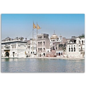 Può includere: Vista di un complesso di templi Sikh con una cupola dorata e una grande piscina d'acqua in primo piano. Il tempio è circondato da edifici e un'asta di bandiera con una bandiera gialla.