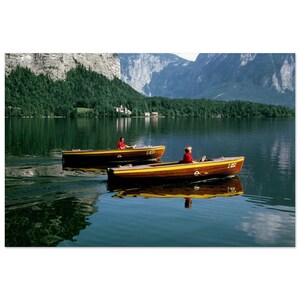 Könnte beinhalten: Zwei Holzboote mit gelber Verzierung befinden sich auf einem See mit Bergen im Hintergrund. Die Boote haben Personen an Bord und die Nummern C 837 und C 838 sind auf den Booten sichtbar.