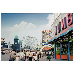 May include: Vintage photograph of a bustling amusement park scene. A large Ferris wheel, bingo sign, and the word "JUMBO" in neon lights are visible. Crowds of people walk along the street under a partly cloudy sky.