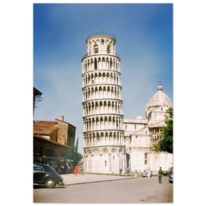 Op de afbeelding: Een uitzicht op de Scheve Toren van Pisa in Italië. De toren is een beroemd monument en een populaire toeristische bestemming. De toren is gemaakt van wit marmer en heeft een kenmerkende kanteling.