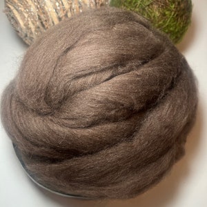 May include: A large amount of brown wool roving, a type of fiber used for spinning yarn or felting.