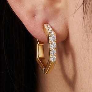 Op de afbeelding: Een set van drie keramische mokken met een gespikkelde, matte afwerking. De mokken zijn in crème, lichtgrijs en donkergrijs. Elke mok heeft een eenvoudig, minimalistisch ontwerp.