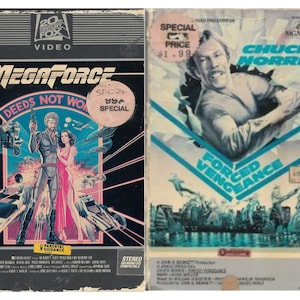 Peut inclure: Deux cassettes VHS, l'une avec un fond noir et le titre "Megaforce" et l'autre avec un fond bleu et le titre "Forced Vengeance" mettant en vedette Chuck Norris.