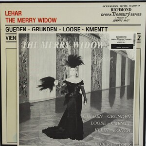Peut inclure: Pochette d'album en noir et blanc pour l'op&eacute;ra "La Veuve Joyeuse" de Leh&aacute;r. La couverture pr&eacute;sente une femme en robe noire et coiffe &agrave; plumes. L'album fait partie de la s&eacute;rie Richmond Opera Treasury.