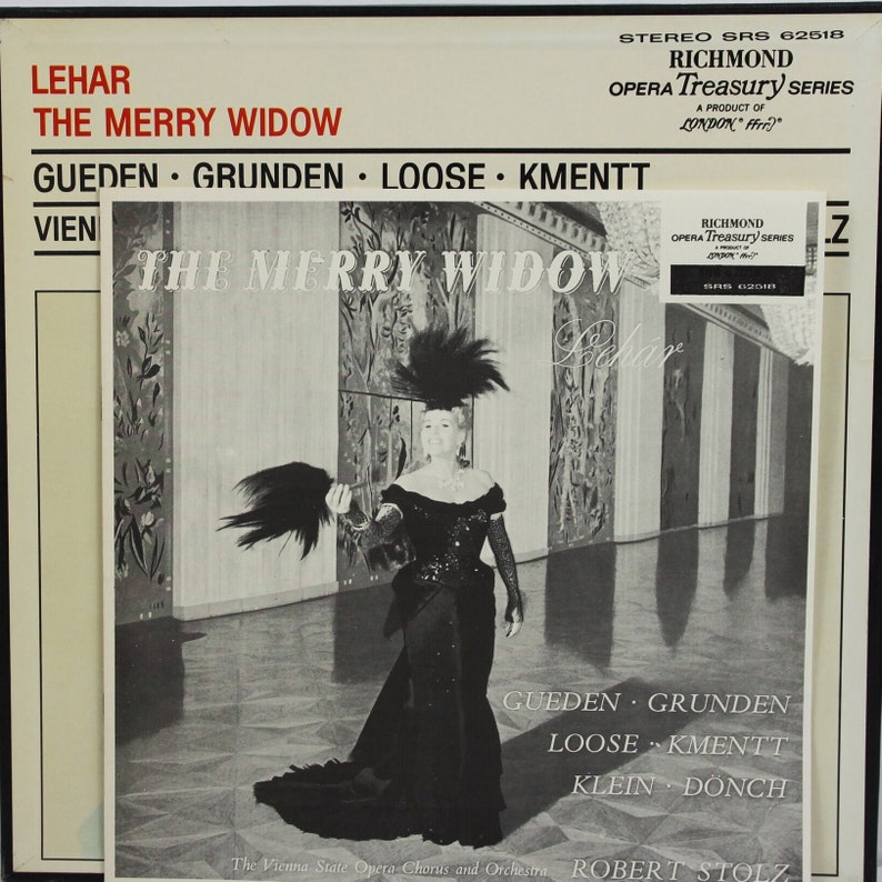 Peut inclure: Pochette d'album en noir et blanc pour l'op&eacute;ra "La Veuve Joyeuse" de Leh&aacute;r. La couverture pr&eacute;sente une femme en robe noire et coiffe &agrave; plumes. L'album fait partie de la s&eacute;rie Richmond Opera Treasury.