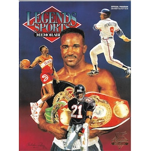 Può includere: Un'illustrazione colorata di quattro atleti di diversi sport. Un pugile è al centro dell'immagine, che tiene una cintura da campione. Un giocatore di basket, un giocatore di football americano e un giocatore di baseball sono sullo sfondo. Il testo "Legends Sports Memorabilia" è nella parte superiore dell'immagine.