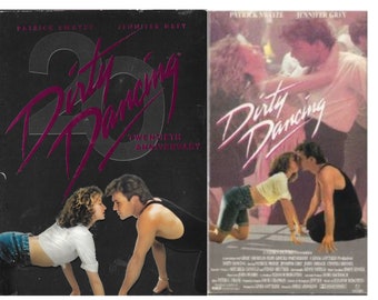 May include: Two VHS tapes of the movie Dirty Dancing. The left tape is a special 20th anniversary edition with a black background and the title in pink. The right tape has a pink and white background with the title in white. Both tapes feature a photo of Patrick Swayze and Jennifer Grey.